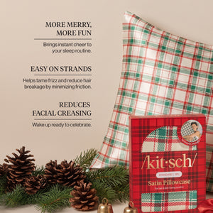 KITSCH Satin Pillowcase in Holiday — infographic of the red, green and cream plaid satin pillowcase beside its red plaid retail box, pine cones, pine branches and brass bells, with callouts More Merry, More Fun, Easy on Strands and Reduces Facial Creasing — Helps tame frizz and reduce hair breakage by minimizing friction — helps reduce facial creasing from sleeping, stays cool and comfortable throughout the night