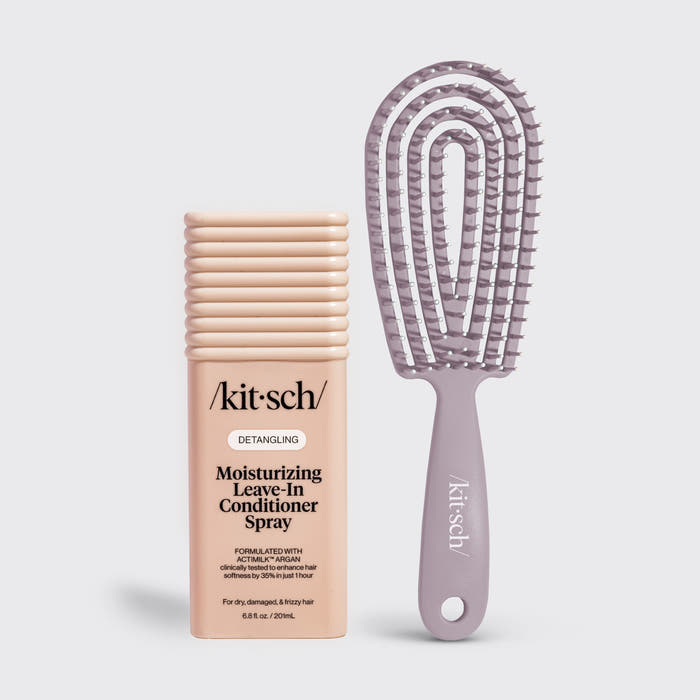 A kitsch Detangling Moisturizing Leave-In Conditioner Spray bottle in a light peach-beige color stands next to a matching lavender-purple detangling hairbrush with a flexible bristle head, on a light gray background.